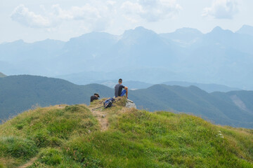 Two hikers in the mountains watching the mountain landscape. Mountain La Nuda, Appenino-Tosco emiliano, Emilia-Romagna, Italy