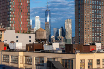 Fototapeta premium The New York City skyline blends historic and modern architecture, with brick buildings and sleek skyscrapers reflecting the sunset. Iconic bridges connect this vibrant metropolis to its surrounding b