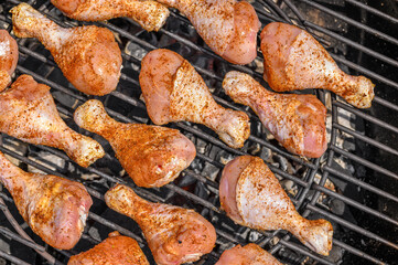 Pałki z kurczaka obsypane papryką pieką się na ruszcie rozgrzanego grilla