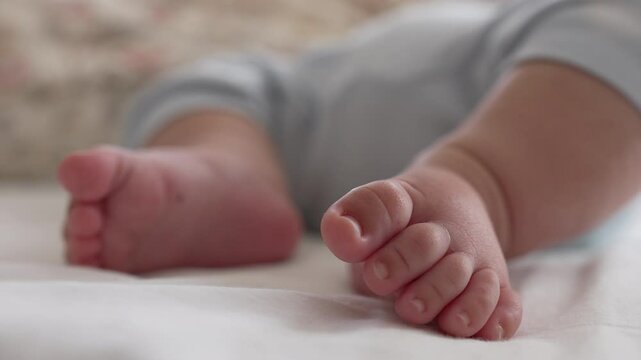 Macro shot of baby&rsquo;s toes on a bed, showing fine details of the foot in a relaxed and peaceful moment of early childhood, highlighting softness and innocence