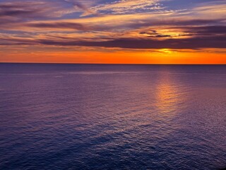 Orange sunset over dark blue purple sea at night. 