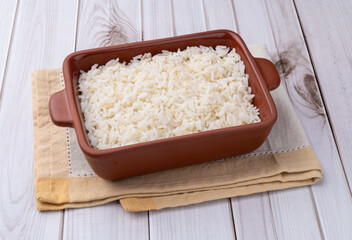 Cooked white rice in a plate over wooden table