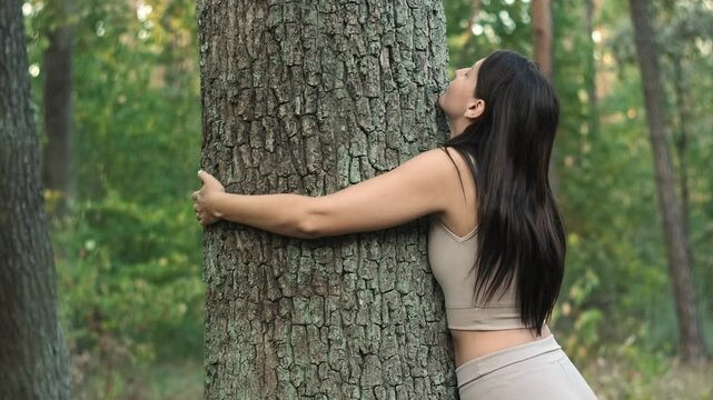 Woman embracing tree in the park. Love of nature. Save Earth