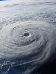 Aerial view of a powerful hurricane swirling over the ocean with dense cloud formations and a clear eye visible from space