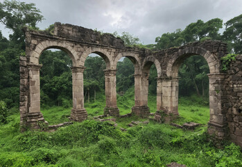 The remnants of Greek architecture stand amidst vibrant trees, with dark clouds overhead, capturing the beauty of history and nature.