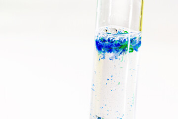 close-up of test tube with polluted water and traces of plastic and micro plastic taken from the ocean, polymer particles, environmental crisis