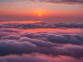 Fototapeta premium A peaceful early morning sky at dawn with low-hanging, fluffy clouds in soft shades of pink and orange, the sun just starting to peek over the horizon 