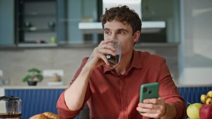 Cellphone man drinking coffee reading message at breakfast in kitchen closeup. - Powered by Adobe