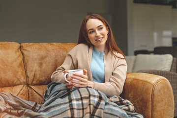 Cozy afternoon relaxation with a warm drink and soft blanket in a serene living room