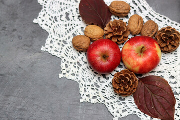 Red apples and autumn leaves on gray background. Top view, copy space