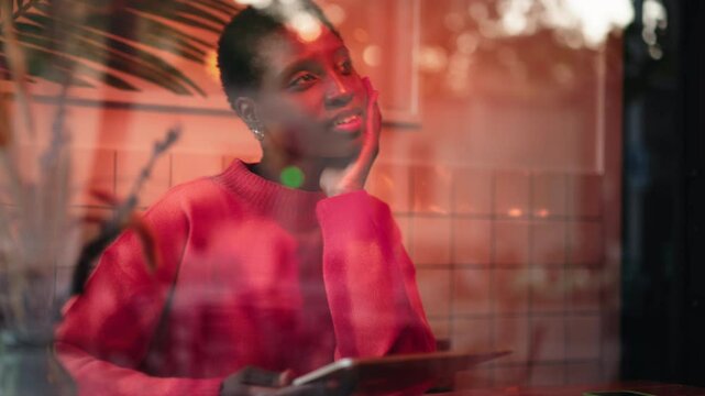 Pensive African American freelancer sitting in coffee shop, holding tablet. flexibility of remote work, Female digital nomad contemplates new ideas and projects, blending technology with creativity
