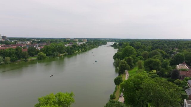Rowing team is gliding through the water, practicing on the Aasee Lake, surrounded by the lush green scenery of Munster, germany