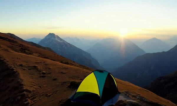Morning sunrise approaching the mountain with single tent