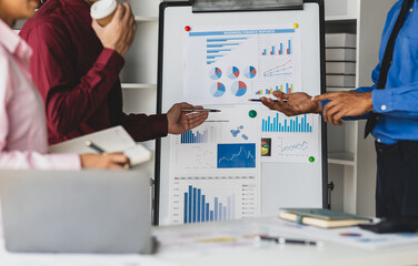 Businessman meeting with colleagues are discussing financial situation analysis on the whiteboard...