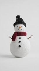 Fototapeta premium A snowman wearing a red scarf and a black hat