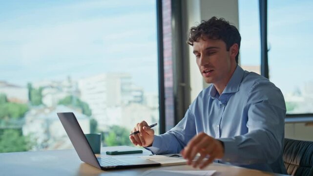 Consultant talking online conference showing document to laptop camera closeup