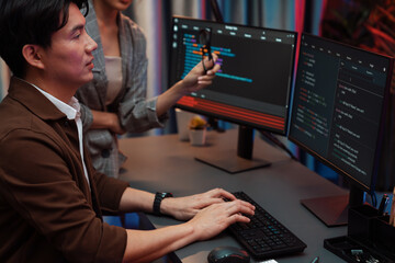 IT developers discussing with point to intelligent website development coder system running data...