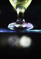 wine glass with some colored bokeh background and dark areas can be used as wallpaper or illustration image