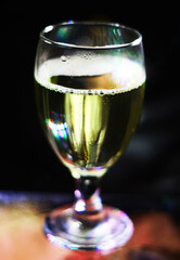 wine glass with some colored bokeh background and dark areas can be used as wallpaper or illustration image