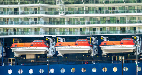 Three semi-enclosed lifeboats, each with a capacity of 150 persons, on a large commercial cruise...