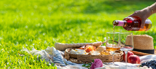 Wine in hands of woman at picnic. Selective focus.