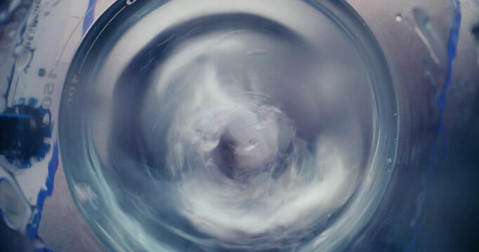 Medical science lab with modern equipment: Top view on magnetic stirrer spinning and stirring fluid materials in glass flask. Drugs or vaccine development. High-tech laboratory device. Close Up Shot.