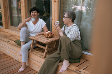 Senior women enjoying coffee on wooden patio
