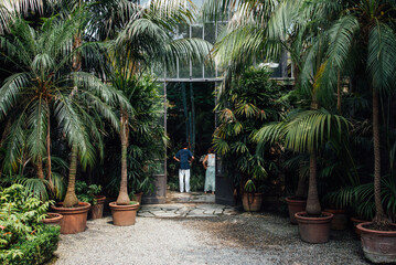 un couple à l'entrée d'une serre. 2 personnes de dos visitant les jardins des îles Borromées. Jardin tropical. Parc luxueux.