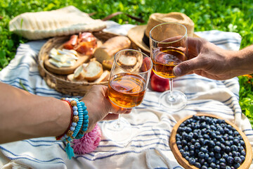 Wine in hands of woman at picnic. Selective focus.