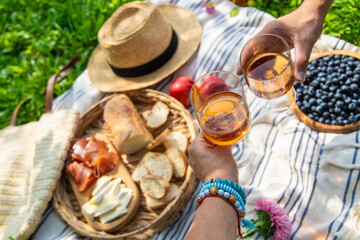 Wine in hands of woman at picnic. Selective focus.