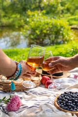Wine in hands of woman at picnic. Selective focus.