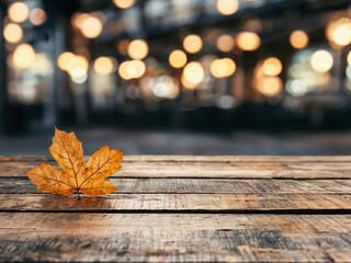 Single autumn leaf lying on empty wooden table
