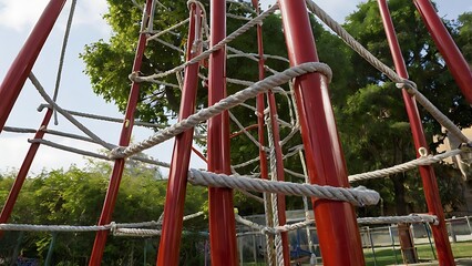 A tall jungle gym standing strong in the playground, its interconnected bars and ropes forming an intricate climbing challenge, inviting exploration.