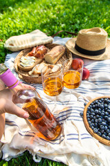 Wine in hands of woman at picnic. Selective focus.