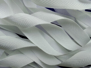 a pile of white  ribbon pieces. rough flat rope texture. halyard. sewing items