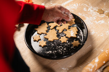 gingerbread cookies in christmas festive shapes in oven tray in kitchen. Making christmas gingerbread cookies.