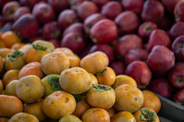 Fresh persimmons displayed on a farmer's market counter
