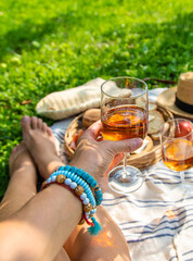 Wine in hands of woman at picnic. Selective focus.