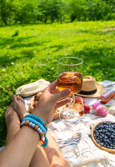 Wine in hands of woman at picnic. Selective focus.