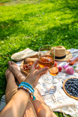 Wine in hands of woman at picnic. Selective focus.