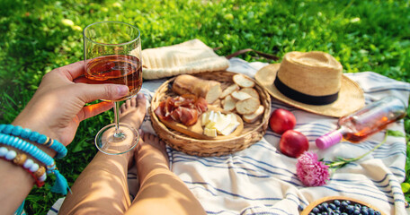 Wine in hands of woman at picnic. Selective focus.