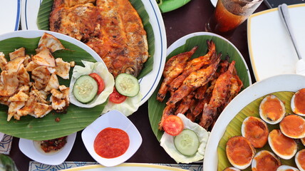 Seafood Meals with Vegetable slices Piled up on a Table at an open air Restaurant on Jimbaran Beach in Bali