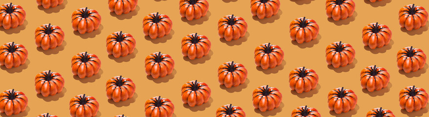 Pattern of orange pumpkins on orange background. long horizontal wallpaper banner, ornament