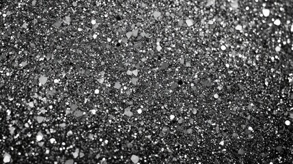 A stunning macro shot of shimmering black glitter, featuring various sizes of glitter particles in a dazzling arrangement.