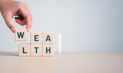 Wealth and investment in success life concept. A hand is holding a woodblock with the letters WEALTH and an arrow-up icon. Business growth and future investment value.