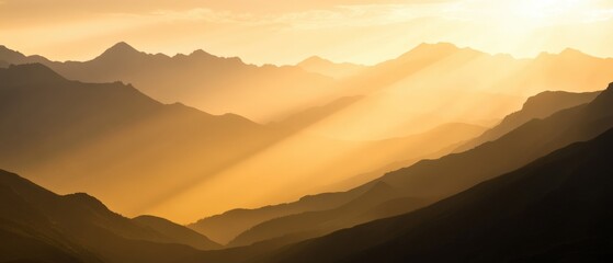 Golden sunrise over serene mountain range casting soft shadows in mist.
