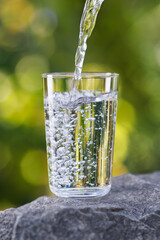 drinking water pouring into glass on stone