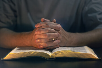 A man reads the Bible. Male hands with Bible close-up.