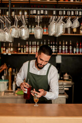 Skilled bartender prepares a cocktail at a stylish bar during a vibrant evening in a bustling city