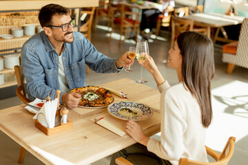 A cozy dinner date between two people enjoying drinks in a stylish restaurant atmosphere